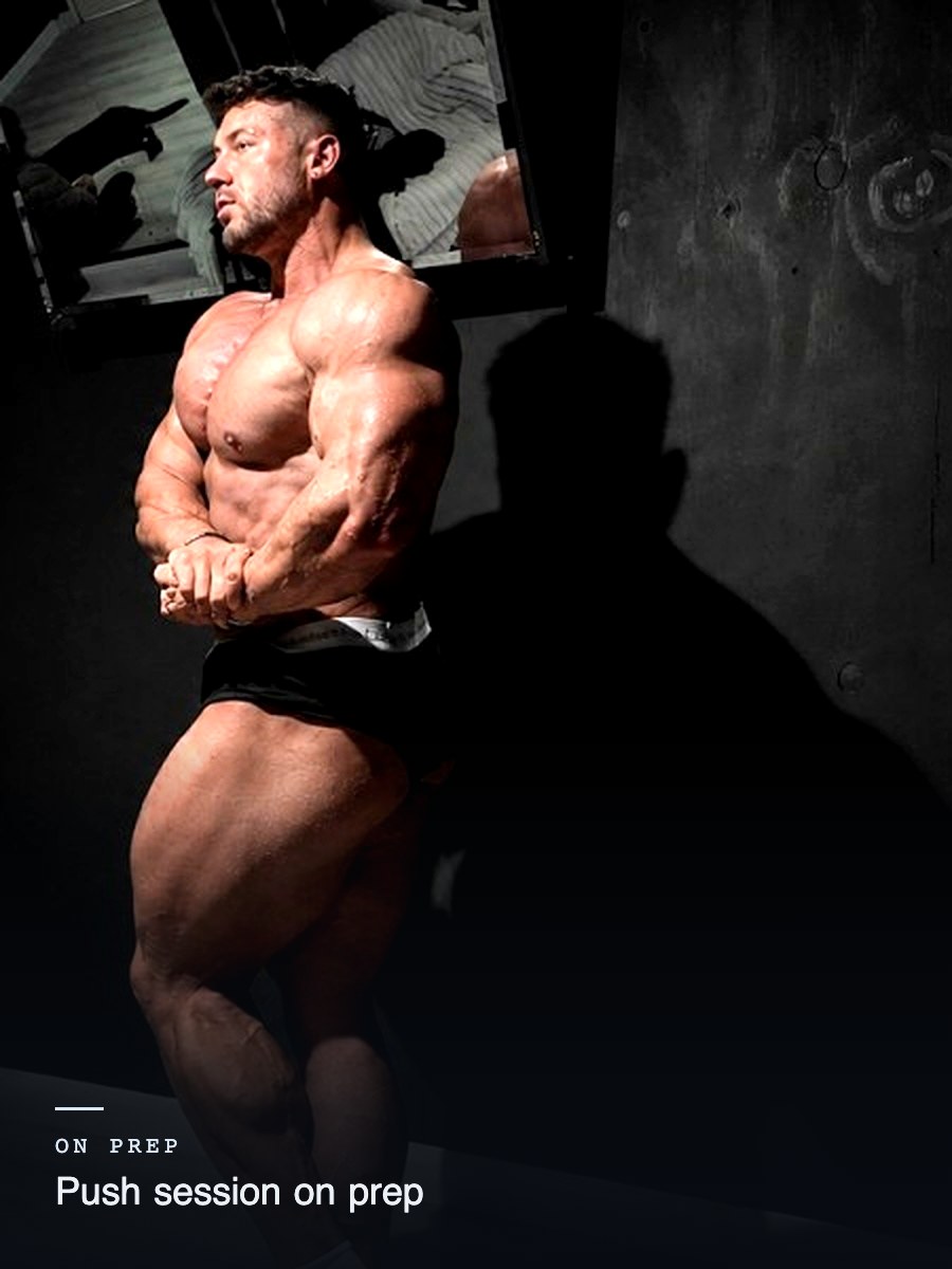 Reece Pearson mid pose in a darkened gym during a push session on prep, 4 of 4
